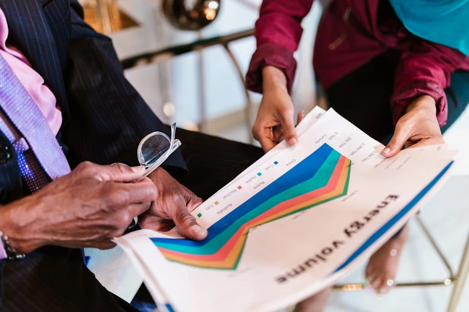 Team diversificato che discute di grafici finanziari in una sala riunioni.